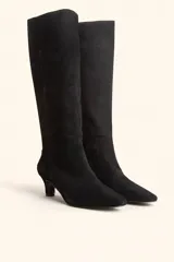 Bota de caña alta confeccionada en gamuza color marrón, con diseño minimalista, punta fina y taco kitten heel de 6 cm.