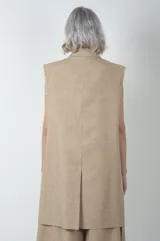 Chaleco largo color beige de lino y viscosa, con solapas y cierre con dos botones.