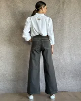 Pantalón de jean estilo wide leg con costuras verticales frontales, tiro alto y bolsillos laterales.