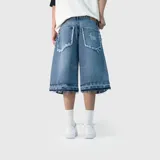 Bermuda de jean estilo baggy con diseño de corte holgado. Presenta un acabado desgastado con bordes desflecados en los bolsillos traseros y en el ruedo, además de un detalle de bordado en uno de los bolsillos posteriores.