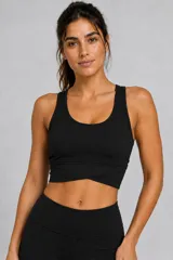 Top deportivo negro con diseño de espalda nadadora y detalle cruzado en el dobladillo inferior.