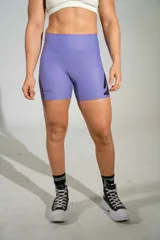 Calza corta deportiva de tiro alto color lila, confeccionada en poliamida y elastano, con logo bordado en la pierna.