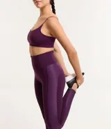 Calza deportiva color violeta con cintura alta y detalle texturizado en la parte trasera. Presenta un pequeño bolsillo funcional. Confeccionada en poliamida y elastano.
