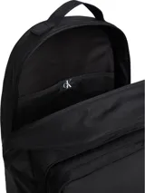 Mochila negra de poliéster reciclado con cierre de cremallera central, asa superior y correas de hombros acolchadas. Tiene un compartimento principal con cremallera, un bolsillo exterior en la parte delantera, funda para portátil y parte trasera de malla acolchada.