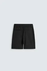 Bermuda de hombre color verde claro, de corte regular y tiro medio, con pinzas frontales, bolsillos laterales y bolsillos traseros de vivo. Cierre frontal con botón y cremallera.