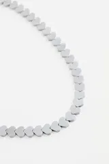 Collar corto de metal con dijes en forma de corazón en tonos verdes.