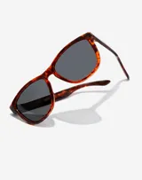 Lentes de sol Hawkers modelo One con armazón de acetato en estampado carey y cristales polarizados oscuros.
