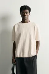 Jersey de punto de manga corta con textura acanalada, cuello redondo y terminaciones en rib en cuello, mangas y ruedo.