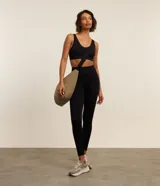 Top deportivo negro, confeccionado en tejido seamless de poliamida y elastano, con escote en U y breteles ajustables. Presenta una banda inferior texturizada y copas removibles.