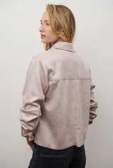 Chaqueta color camel con cuello camisero, cierre frontal con botones dorados, dos bolsillos de parche en el pecho y costuras decorativas en contraste.