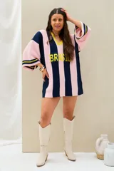 Remerón tejido de punto oversize con diseño de rayas verticales en color azul marino y rosado, cuello en V con borde amarillo y mangas largas.