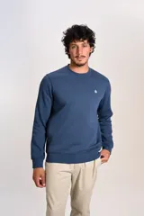 Buzo de cuello redondo en color azul, con diseño liso y logo bordado pequeño en el pecho. Presenta puños y ruedo acanalados.
