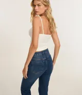 Pantalón de jean modelo flare cropped, de tiro alto, con bolsillos funcionales y cintura con trabillas. Presenta un corte ceñido en caderas y muslos con una ligera apertura acampanada desde la rodilla y ruedo deshilachado.