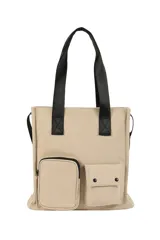 Bolso tipo tote color beige con doble asa superior negra y correa ajustable. Presenta un diseño estructurado con dos bolsillos frontales funcionales, uno con cierre y otro con solapa y broches a presión.
