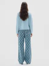 Polera de punto en color celeste, con cuello alto y manga larga. Presenta un pequeño logo bordado en el centro del pecho y terminaciones en tejido acanalado.