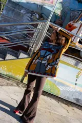 Buzo de tejido de punto con diseño jacquard de carrusel, cuello redondo, mangas largas y corte holgado. Presenta detalles de rib en puños, cuello y ruedo.