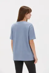 Remera de algodón negro con cuello redondo y diseño holgado, con estampado frontal de líneas horizontales blancas y un corazón rojo superpuesto.