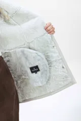 Campera de cuero tipo lambskin con diseño de paneles, cuello con solapas de piel sintética, cierre frontal con botones y bolsillos laterales.