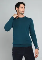 Sweater de algodón color verde petróleo, con cuello redondo y mangas largas.