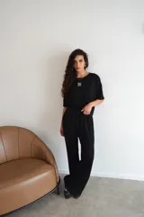 Pantalon de corte recto y holgado, confeccionado en tejido de mezcla de algodón y poliéster, con cintura elástica y cordón ajustable.