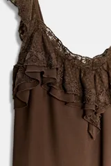 Top de color marrón con escote en pico, tirantes anchos y detalle de volantes con bordados a tono en el escote y los hombros.