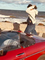 Riñonera de cuero con estampado animal print de vaca en blanco y negro, con correa regulable y cierre superior.