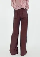 Pantalón de jean de tiro alto, corte palazzo, color ladrillo con costuras laterales a contratono.