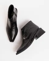 Bota corta de cuero vacuno con acabado metalizado y textura de reptil. Presenta punta fina, cierre lateral interno y taco cuadrado de madera.