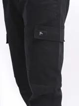 Pantalón cargo negro con bolsillos laterales con solapa, corte recto y cintura elástica.