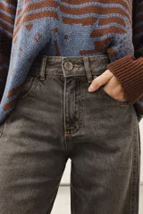 Jean de corte recto y largo, de tiro medio, color gris oscuro con efecto lavado. Presenta un bordado de estrella en los bolsillos traseros.