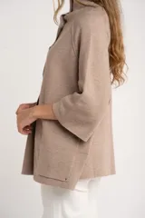 Cárdigan marrón de tejido de punto con cuello alto, manga 3/4 y cierre frontal con botones.