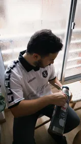 Camiseta de fútbol estilo boxy color blanco, con cuello polo y ribetes negros en las mangas. Presenta detalles estampados y bordados exclusivos en el frente y hombros.