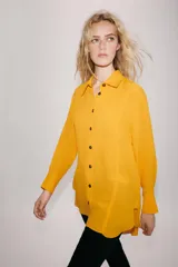 Camisa de viscosa color naranja de la colección ZW Collection de Zara, con cuello solapa, manga larga con puño, bajo asimétrico y cierre frontal con botones a contraste.