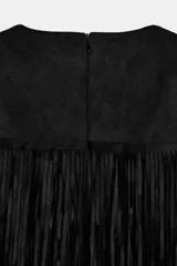 Vestido corto negro, sin mangas, con cuello redondo y múltiples capas de flecos que cubren todo el cuerpo de la prenda.