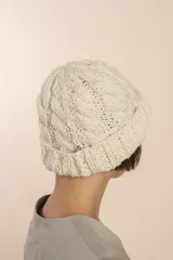Gorro tejido a mano con diseño de ochos, color marrón y blanco jaspeado.