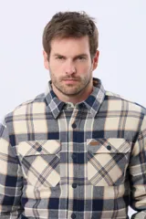 Campera leñadora de viyela a cuadros en tonos beige y azul oscuro, con interior forrado en corderito, cierre frontal con botones y dos bolsillos con solapa en el pecho.