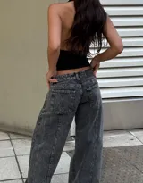 Pantalón de jean tipo wide leg con tiro bajo y lavado acid wash en tono gris oscuro. Presenta costuras verticales decorativas en el frente y bolsillos laterales.