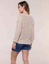 Buzo liviano de algodón con tejido de punto abierto y semi holgado, color beige, con escote bote, mangas largas de hombros caídos y costuras expuestas.
