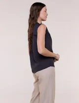 Blusa de gasa sin mangas de calce holgado, marca Sioni. Cuenta con cuello cadete, abertura frontal en V con media cartera de botones, espalda con canesú y pliegue central, y ruedo redondeado.