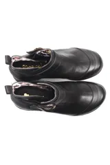 Botin de cuero negro con suela de goma tipo burbuja, diseño clásico con hebilla metálica lateral y elásticos para mayor ajuste.