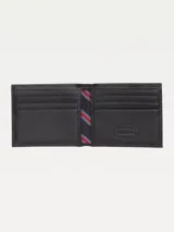 Billetera plegable de cuero negro liso con forro estampado a rayas. Incluye múltiples ranuras para tarjetas y billetes, y logo pequeño de Tommy Hilfiger en la parte inferior.