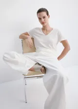 Camiseta de lino color blanco, con cuello en V y mangas cortas, de corte recto y clásico.