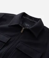 Campera pesada tipo trucker de Marfinno, confeccionada en polivelour negro. Presenta cuello camisero, cierre frontal con cremallera y dos bolsillos frontales con solapa en el pecho.
