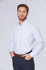 Camisa casual celeste de manga larga con diseño a rayas finas, cuello con botones y bolsillo ojal en el pecho con logo bordado.