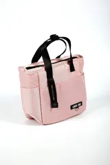 Lunchera rosa con asas negras y cierre superior. Tiene un bolsillo lateral y un logo con la inscripción "LUNCH BAG".
