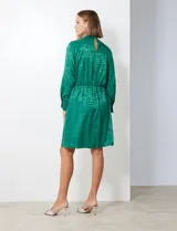 Vestido corto color borgoña con estampado geométrico, de gasa laminada con cuello alto entrelazado, manga larga raglán, cintura elastizada y espalda con abertura ojal y botones.