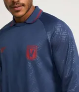 Camisa masculina con cuello polo con raya contrastante, mangas largas, puños ajustados con raya contrastante, estampas localizadas en el pecho y estampa heatprint. La prenda posee tecnologia dry.