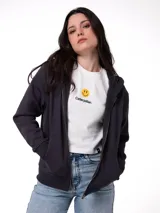 Campera canguro de felpa negra con cierre frontal metálico, capucha forrada y bolsillos tipo parche. Presenta puños y cintura de punto acanalado.