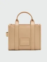 Cartera tipo tote de Marc Jacobs, confeccionada en cuero granulado negro. Presenta el logo de la marca estampado en el frente y doble asa superior.