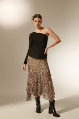 Top de manga larga con diseño asimétrico de un solo hombro, confeccionado en tejido negro con acabado brillante tipo glitter y ajuste al cuerpo.